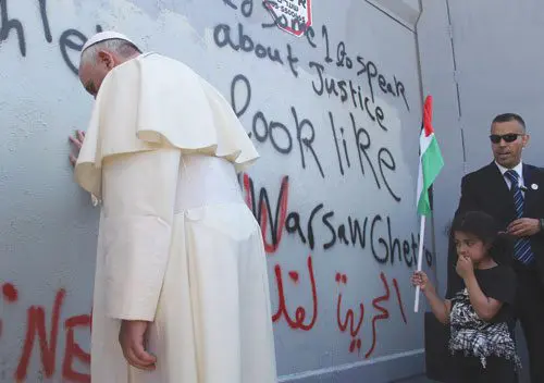 Pope Francis prays at the wall of separation in Bethlehem