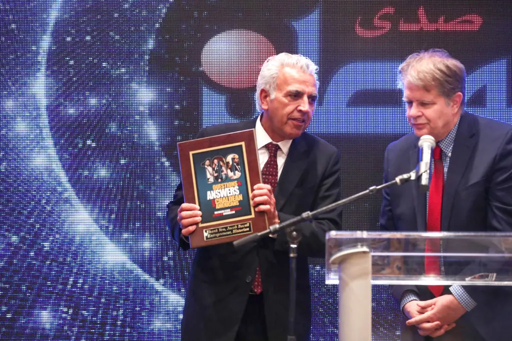 Jacob Bacall receiving his award from Michigan State University Journalism Professor Joe Grimm