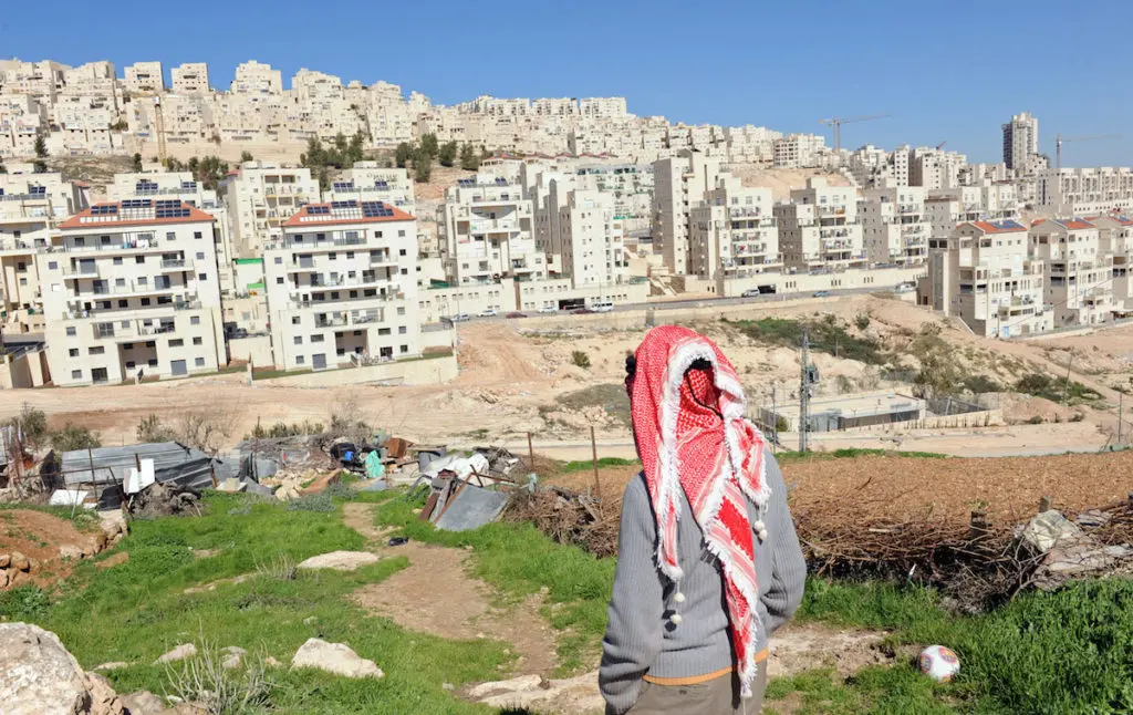 A Palestinian stands on his property overlooking the Israeli settlement Har Homa, West Bank, Feb. 18, 2011. Photo: Debbie Hill