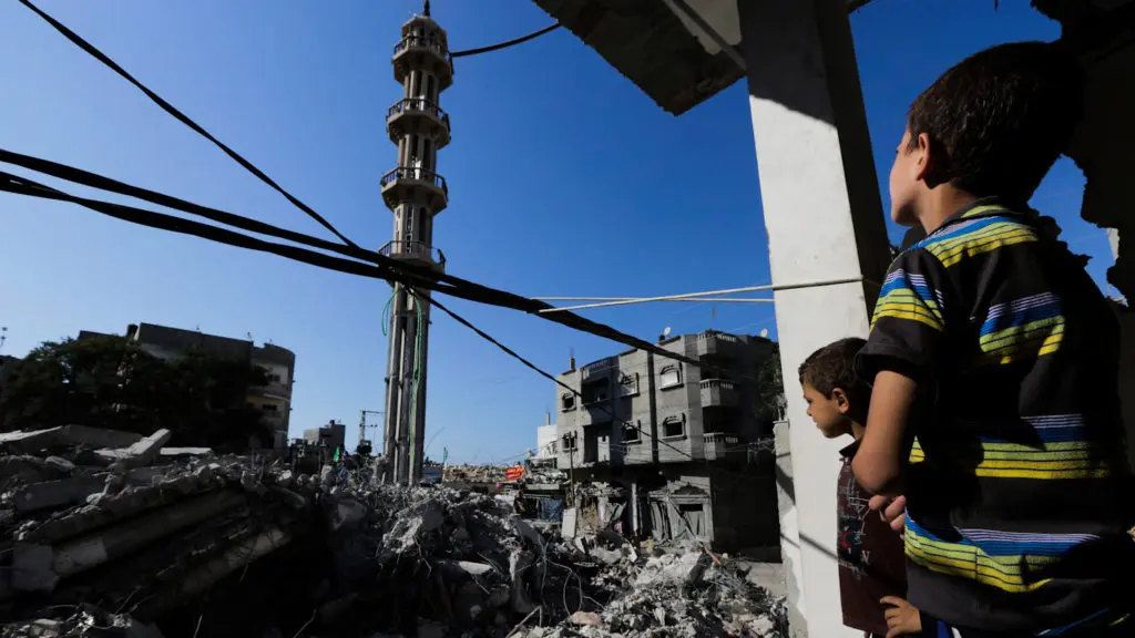 Palestinian boys look at the rubble of al-Qassam mosque, hit by an Israeli airstrike on Saturday, as they stand in the bedroom of their destroyed family house in Nusseirat refugee camp in the central Gaza Strip on Sunday, Aug. 10, 2014. Photo by AP