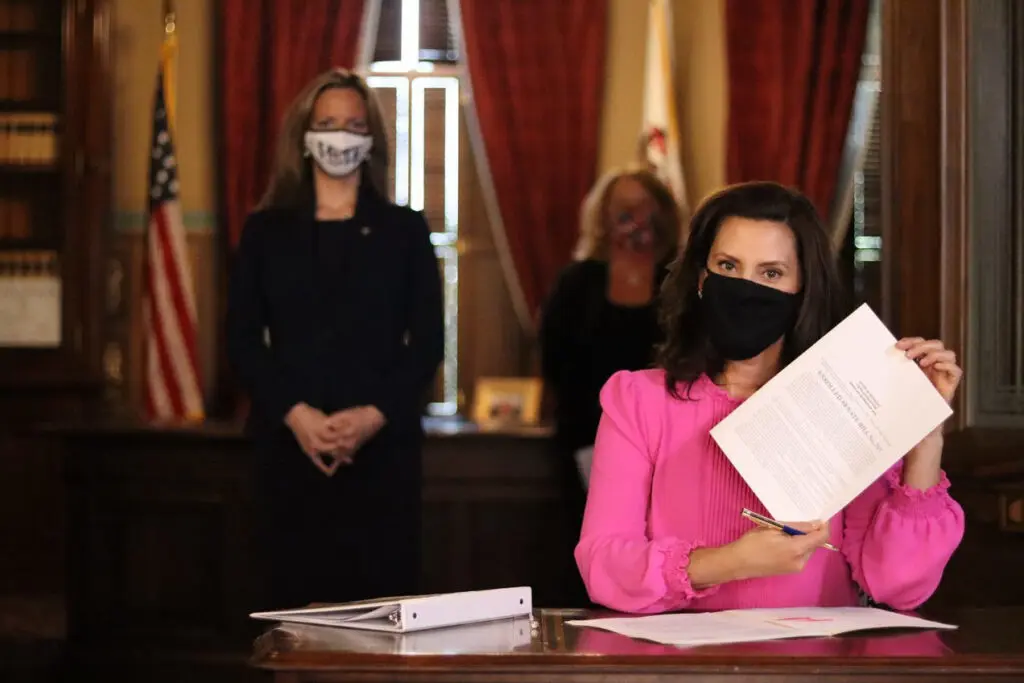 Governor Whitmer signs a senate bill that allows clerks of cities with a population of over 25,000 to pre-process absentee ballots ahead of the Nov. 3 election, at a special press conference in Lansing, Tuesday, Oct. 6. Photo: Office of the Governor