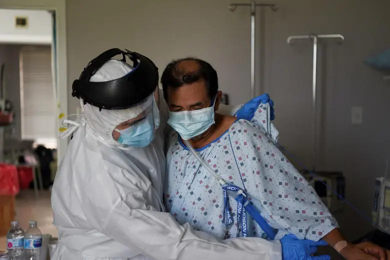 Fernando Olvera, 26, a medical school student, helps Efrain Guevara, 63, who has been hospitalised with COVID-19, get up from his hospital bed at United Memorial Medical Center in Houston, Texas, July 17. REUTERS/Callaghan O'Hare