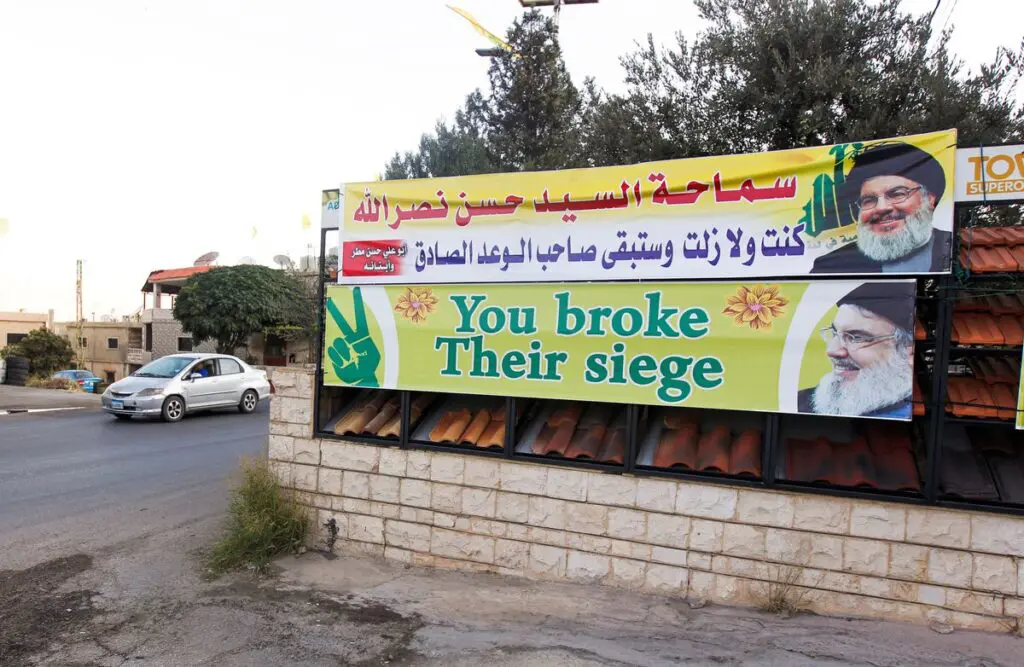 A car rides near banners depicting Lebanon's Hezbollah leader Sayyed Hassan Nasrallah as the first truck carrying Iranian fuel is expected to reach Lebanon today, near the Lebanese-Syrian border, in al-Ain village, Lebanon Sept. 16. Photo: Reuters