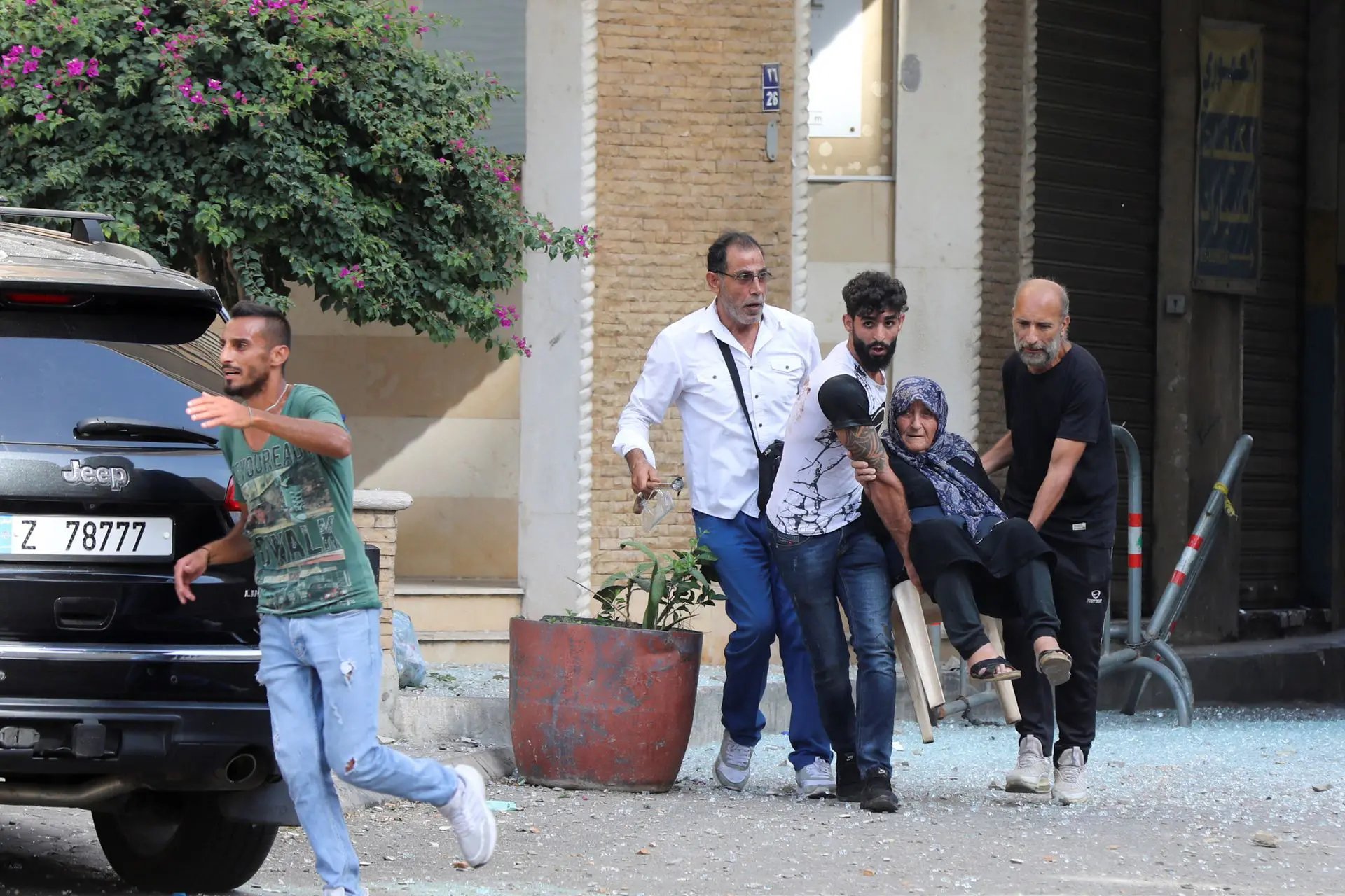 Men help evacuate an elderly woman after gunfire erupted, in Beirut, Lebanon Oct.14. Photo: Mohamed Azakir/Reuters