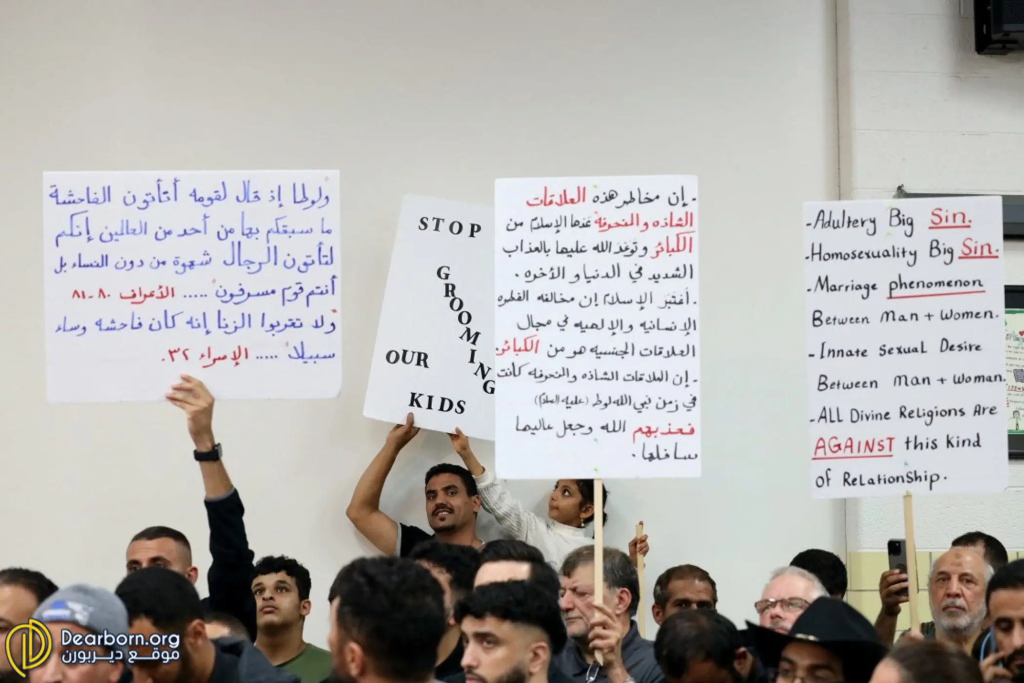 Protestors hold signs at the Dearborn Public Schools Board of Education meeting on Monday, Oct. 10 before it was shutdown by Dearborn Police and Fire, to be reconvened later in the week. Photo: Dearborn.org
