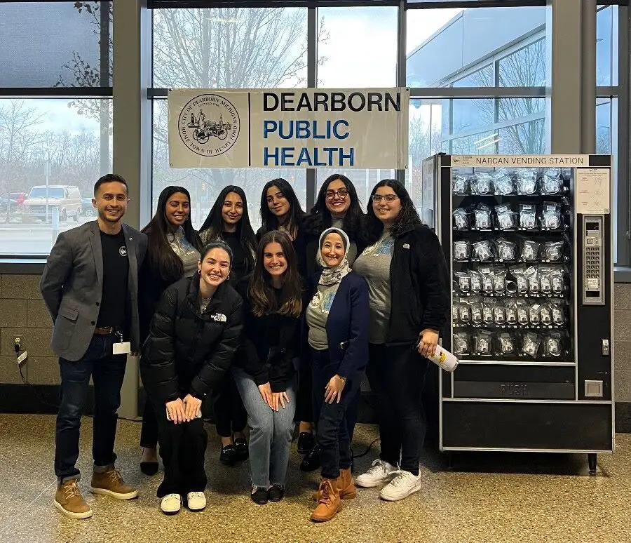 Dearborn Director of Public Health Ali Abazeed (l) stands with DPH fellows and the new Narcan vending station at the Dearborn Train Station. Photo: City of Dearborn
