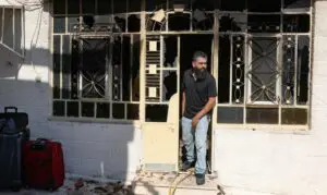A Palestinian man prepares to leave his home, taking a few suitcases with him, after it was set on fire by Israeli settlers in Turmus Aya, occupied West Bank, June 21, 2023. - Photo by AFP