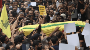 People carry the body of a fighter of the Lebanese Hezbollah movement during his funeral after he was killed in clashes – AFP