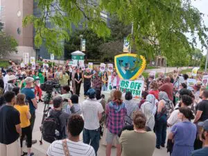 Protesters on WSU's campus hold signs calling for divestment from Israel after the removal of the encampment.