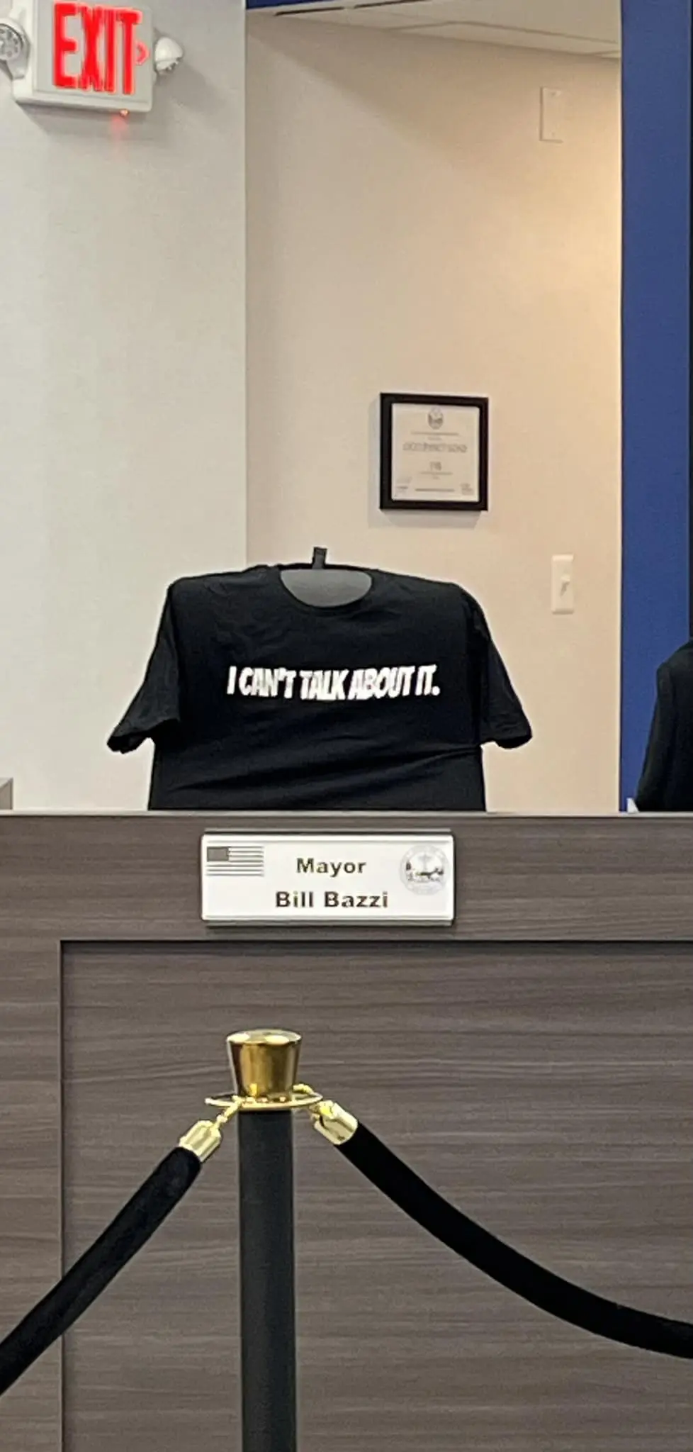 Photo of Mayor Bill Bazzi's empty seat with a shirt placed by Councilman Hassan Saab saying "I Can't Talk About It" Photo: Hassan Saab