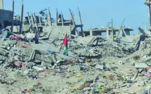 A Palestinian flag stands amid the rubble of homes in the Jabaliya refugee camp. –  (Photo: via QNN)