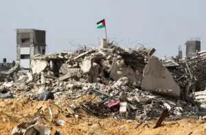 A Palestinian flag flutters among the rubble of buildings destroyed during the Israeli offensive, amid a ceasefire between Israel and Hamas, in Rafah in the southern Gaza Strip February 4. - Photo by Reuters