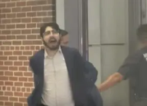 Elias Rodriguez, 31, from Chicago, is led away from inside a museum, outside which the embassy staff members lay dead. – Videograb