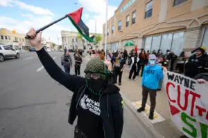 Demonstrators shout and wave flags during a counter-protest in response to a planned book burning in front of the Islamic Center of Hamtramck, May 10, 2026. ,Photo by the Detroit 