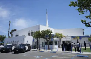 People gather as police vehicles are parked outside of the Islamic Center of San Diego, the day after a shooting, in San Diego,Tuesday, May 19. - Video grab