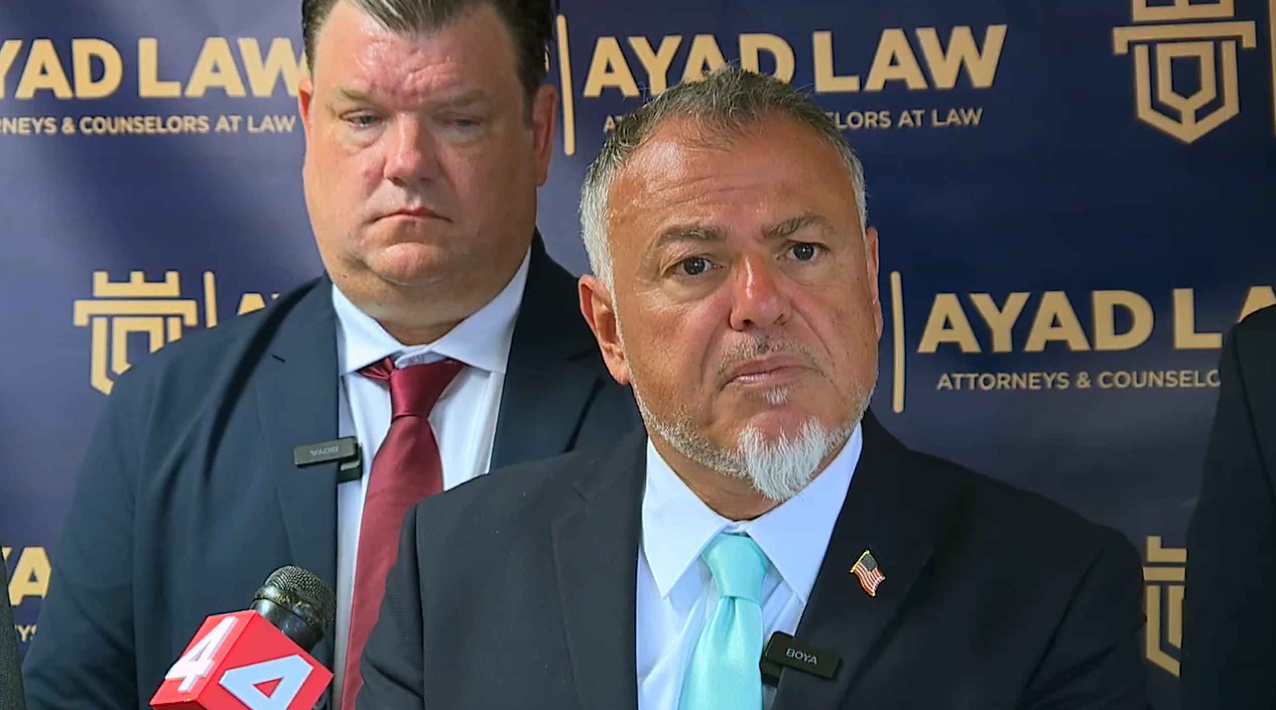 Attorney Nabih Ayad speaks during a press conference announcing the filing of a federal lawsuit against U.S. Department of Health and Human Services agents, with Dr. Anthony Wienert standing behind him on Tuesday, June 9 in Detroit– Video grab
