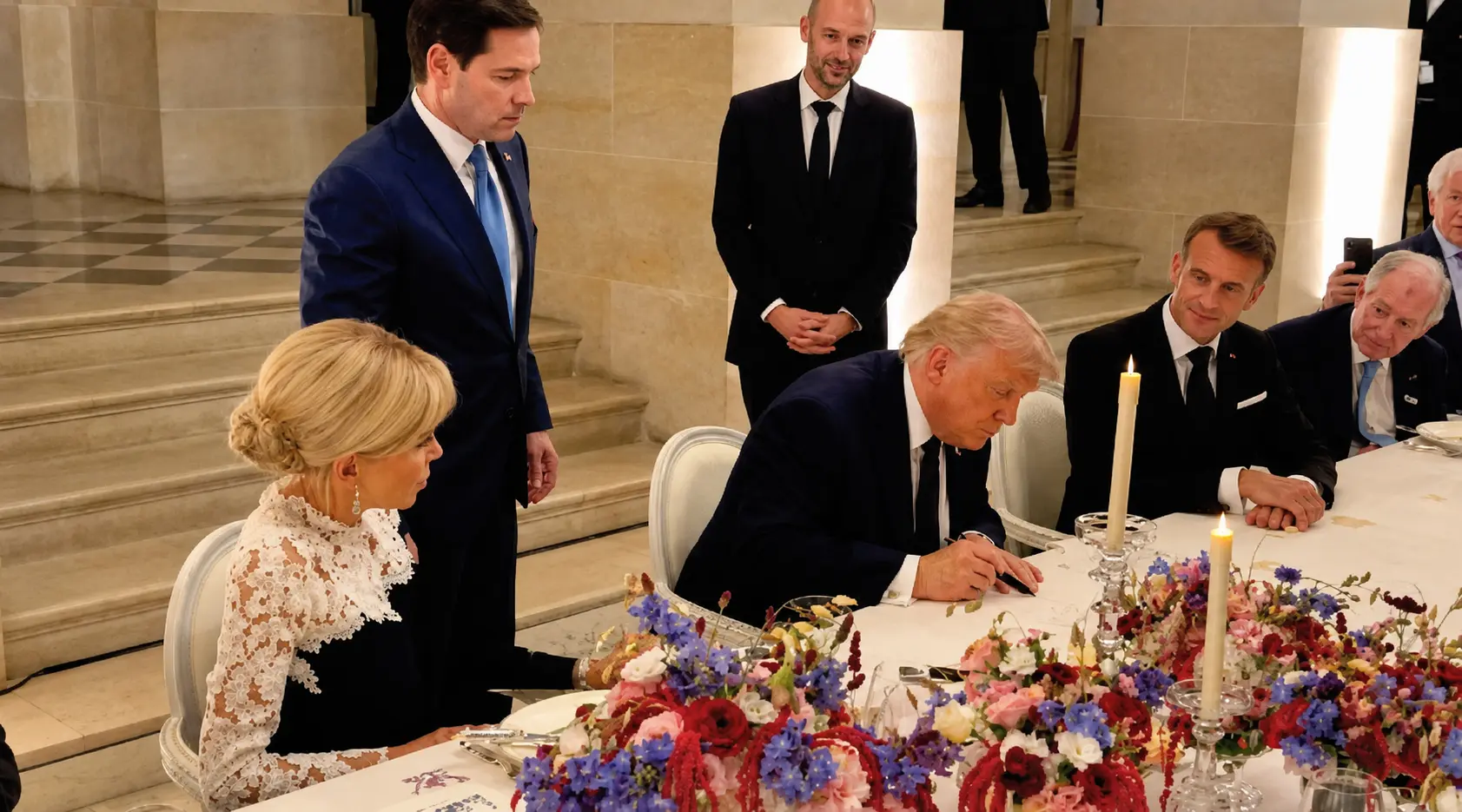 President Trump signs the agreement during a dinner with President Macron at the Palace of Versailles in France following the G7 summit. – Video grab