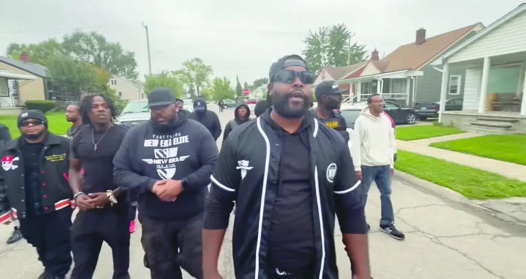 African American men walk through a predominantly Arab residential neighborhood in Detroit's Warrendale area to protest the treatment of an African American woman following a traffic collision last month.
