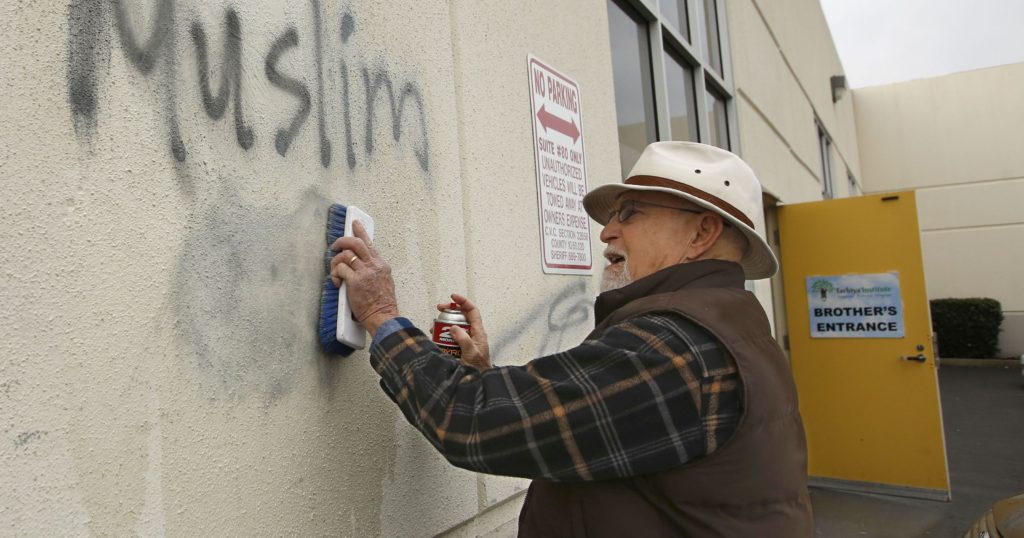 Tom Garing cleans up racist graffiti painted on the side of a mosque in what officials called an apparent hate crime, in Roseville, Calif. Feb. 1, 2017. File photo y AP