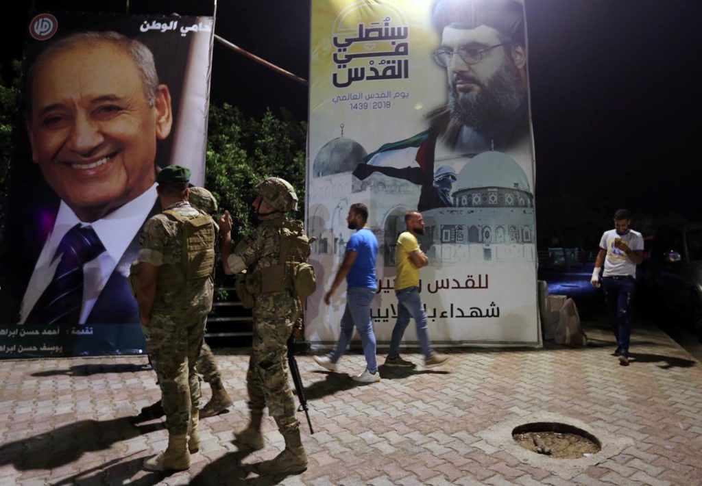 Lebanese army soldiers stand near a poster of Lebanon's Hezbollah leader Sayyed Hassan Nasrallah in Adaisseh village near the Lebanese-Israeli border, Lebanon August 28, 2019. REUTERS/