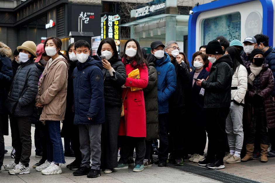 People wearing masks after the coronavirus outbreak wait in a line to buy masks in front of a department store in Seoul, South Korea, February 28, 2020. REUTERS