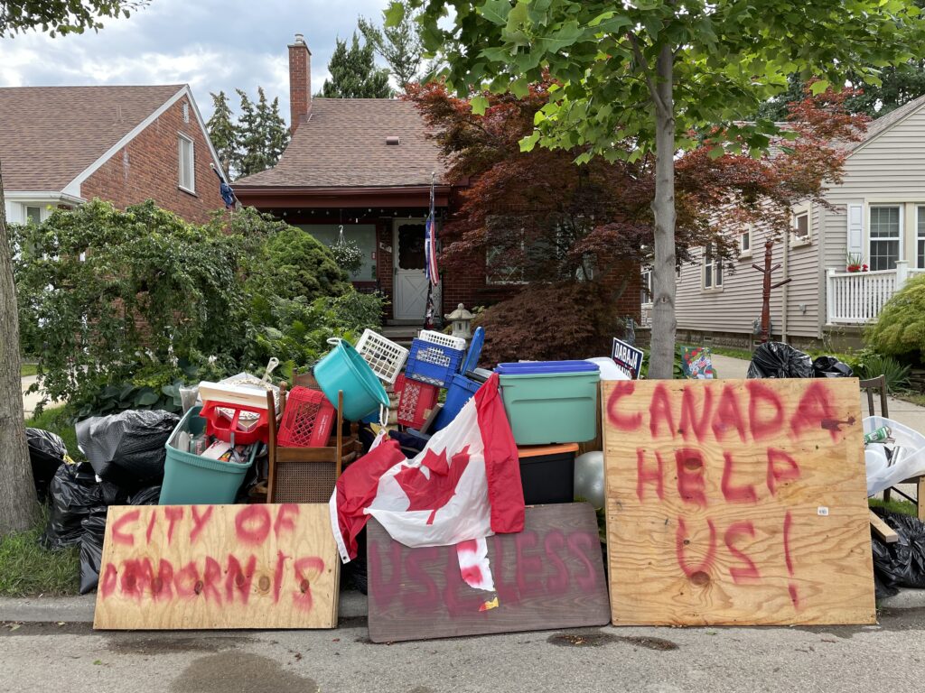 Signs ask for help from Canada after flooding in East Dearborn