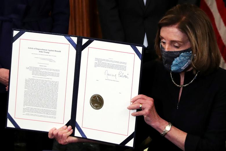 House Speaker Nancy Pelosi shows the article of impeachment against President Trump after signing it in an engrossment ceremony at the U.S. Capitol, Jan 13. Photo: Leah Millis 