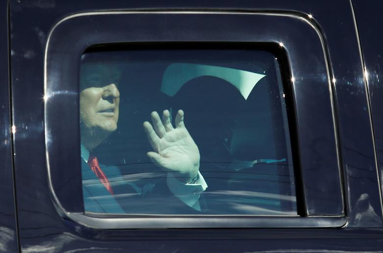 President Donald Trump waves from a car as he drives past supporters in West Palm Beach, Florida, January 20, 2021. REUTERS/Marco Bello