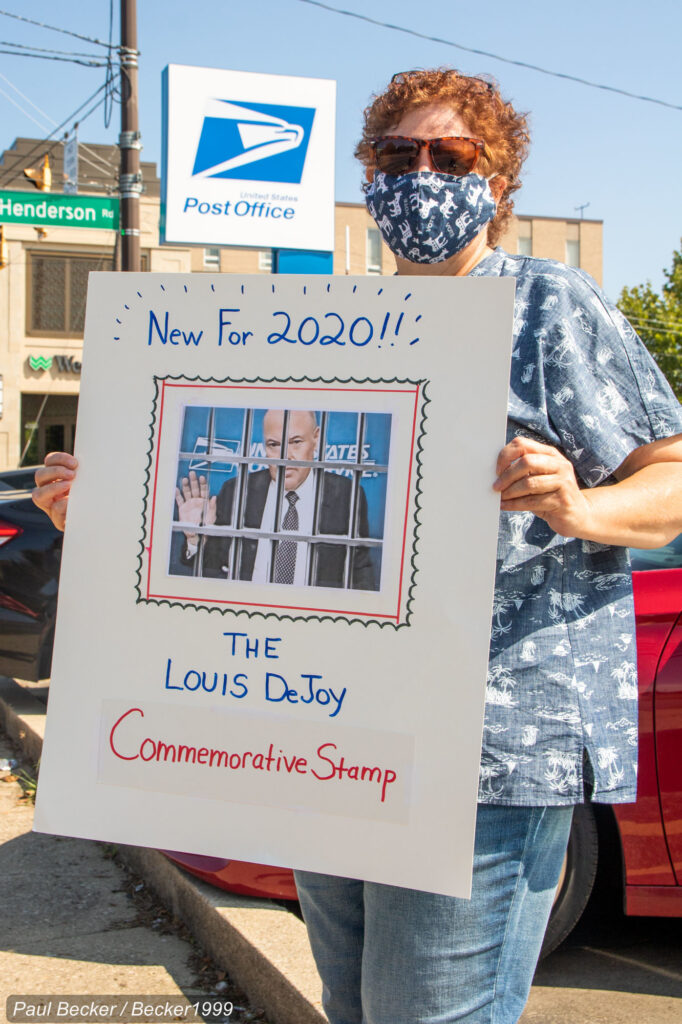 A woman holds a sign at a protest against sweeping USPS changes by Postmaster General, Louis DeJoy, in Ohio, Aug. 2020. Photo: Paul Becker