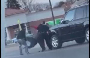 The officer and bystanders wrestle Murphy to the ground. Photo: Screenshot/Dearborn Area Community Members Facebook