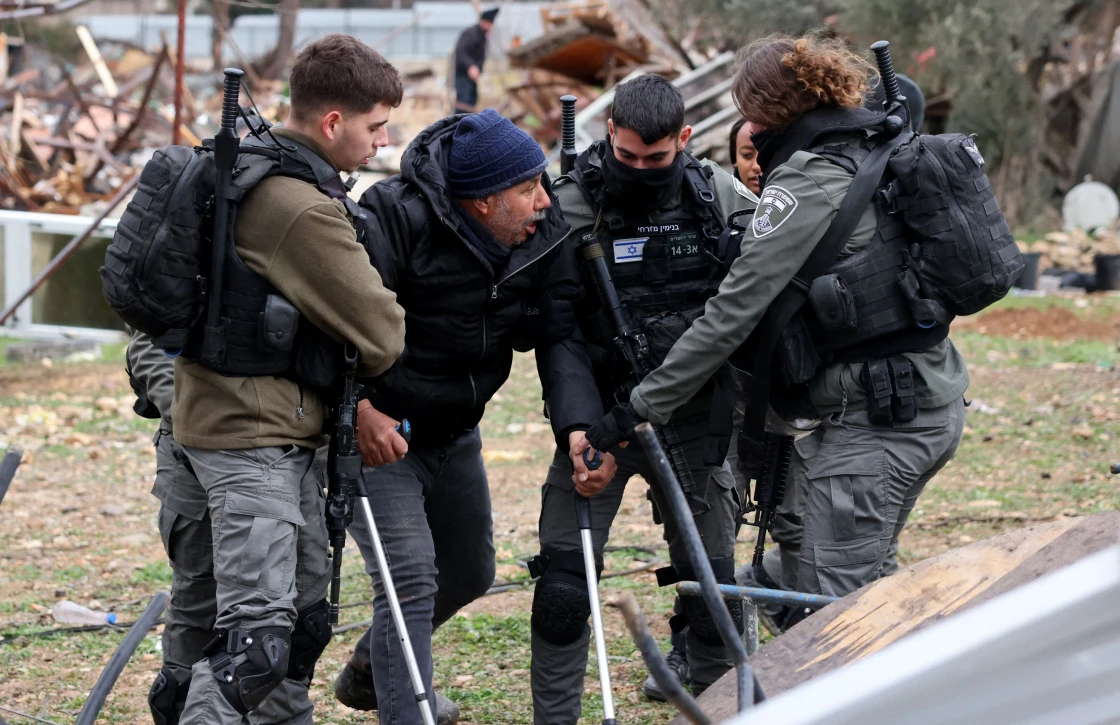 Israeli forces remove a man on crutches away from the ruins of a Palestinian house they demolished in the Sheikh Jarrah neighborhood on Wednesday. Photo: Ahmad Gharabli/AFP