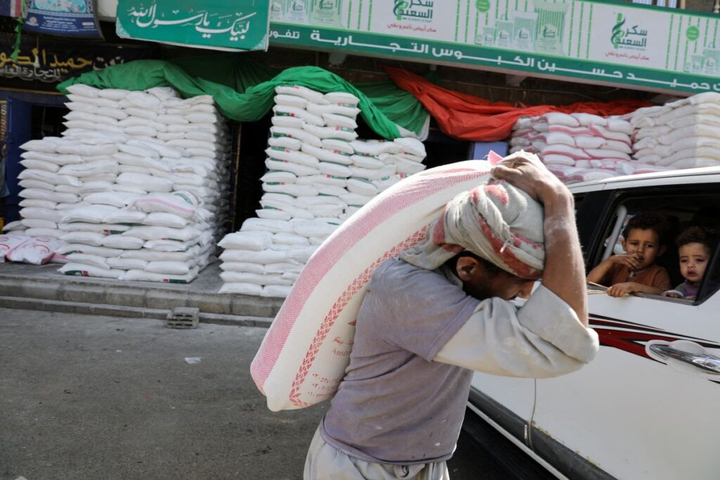 A worker carries a sack of wheat flour outside a wholesale food shop in Sanaa, Yemen February 28, 2022. Picture taken February 28. – REUTERS