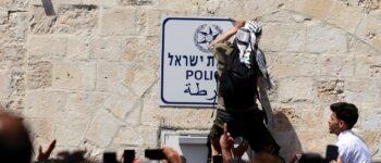 A Palestinian man takes a police sign off a wall at the compound that houses Al-Aqsa Mosque, known to Muslims as Noble Sanctuary and to Jews as Temple Mount, following Israeli forces attacks on Palestinians in Jerusalem's Old City April 15. Photo: Ammar Awad/Reuters