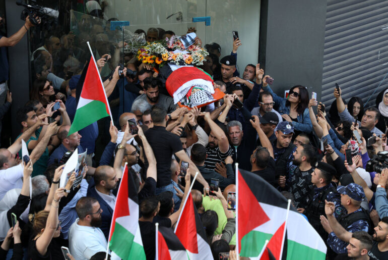 Palestinians carry the body of Al Jazeera journalist, killed by Israeli forces in occupied West Bank, towards the offices of the news channel in Ramallah, May 11. Photo: Wajed Nobani/APA