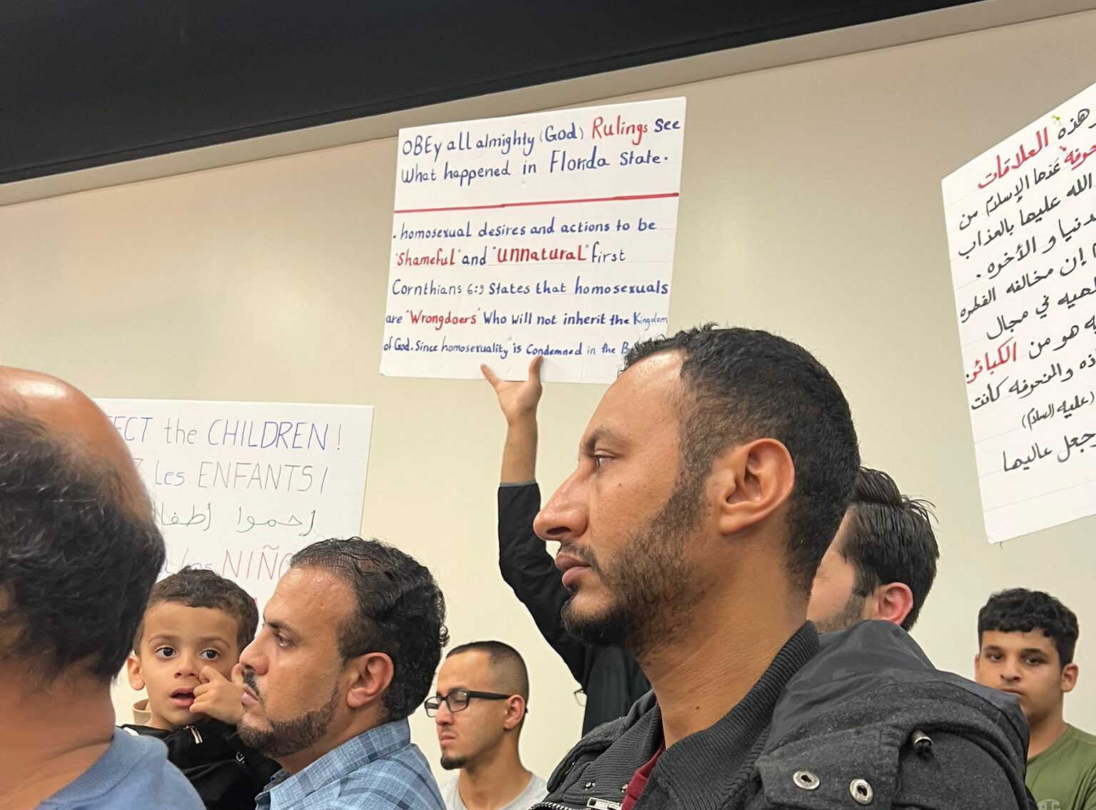 Signs held by protests at a Dearborn Public Schools Board of Education meeting on Monday, Oct. 10. Photo: The Arab American News