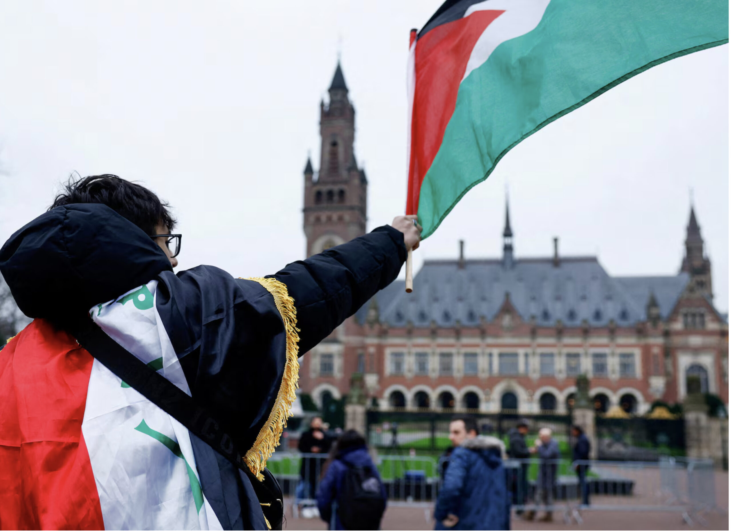 A man waves a Palestinian flag as people protest on the day of a public hearing held by The International Court of Justice (ICJ) to allow parties to give their views on the legal consequences of Israel's occupation of Palestinian territories before eventually issuing a non-binding legal opinion, in The Hague, Netherlands, February 21. – Reuters