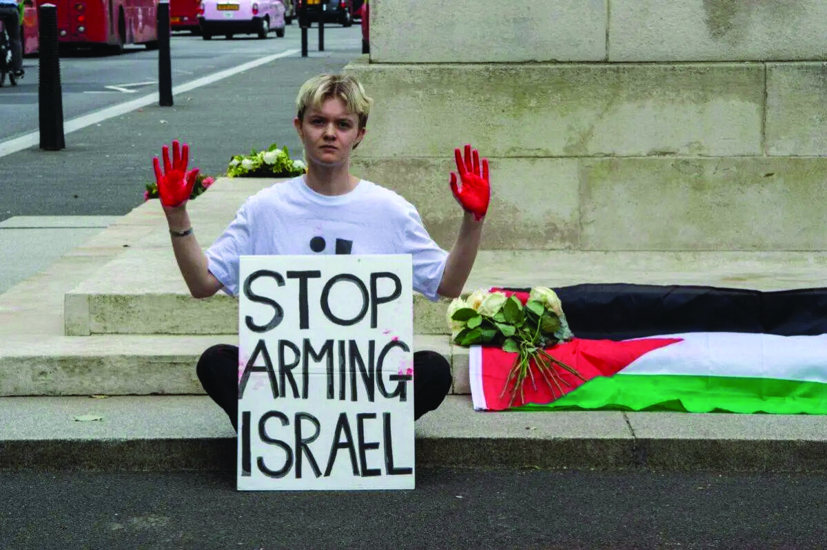 Activists from Youth Demand place flowers and a Palestinian flag on the Cenotaph in London, England on July 15. – Photo from Middle East Monitor website