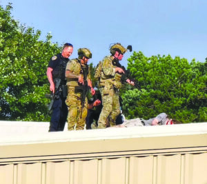 Law enforcement officers stand over the shooter in Butler, Pa., on July 13.