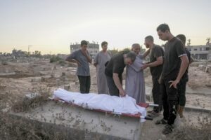 Palestinian mourners prepare to bury their loved one at the cemetery in Deir al-Balah, Gaza Strip, Friday, Aug. 9, 2024. - Photo by AP