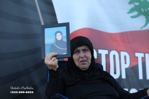 Hajji Hayat Jaafari, who was among the protesters, holds up a picture of her daughter, Samar Al-Sayyid, who had been killed in a recent Israeli airstrike on the southern Lebanese city of Bint Jbeil.