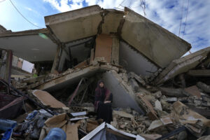 Mariam Kourani, 56, sits on the rubble of her destroyed house after she returned with her family to Hanouiyeh village in southern Lebanon, Thursday, November 28. – AP.