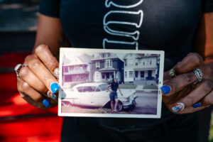 Jeanine holds a photo of her grandmother in front of her house in 1965