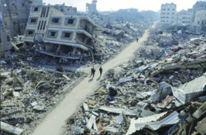 Palestinians walk past destroyed buildings in the Jabalia refugee camp in northern Gaza. – File photo