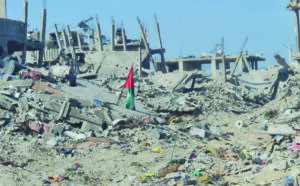 A Palestinian flag stands amid the rubble of homes in the Jabaliya refugee camp. –  (Photo: via QNN)