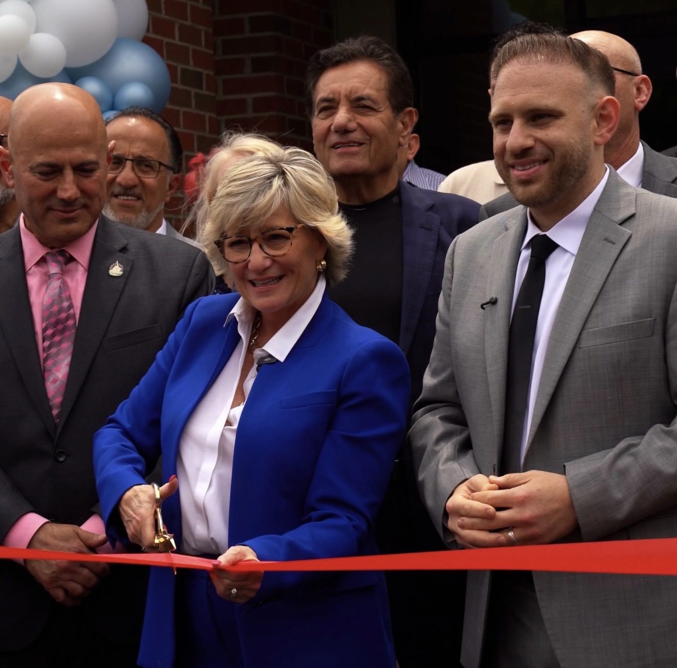 Dr. Ali Bazzi and Mayor Maureen Brosnan cutting the ribbon at the grand opening ceremony.