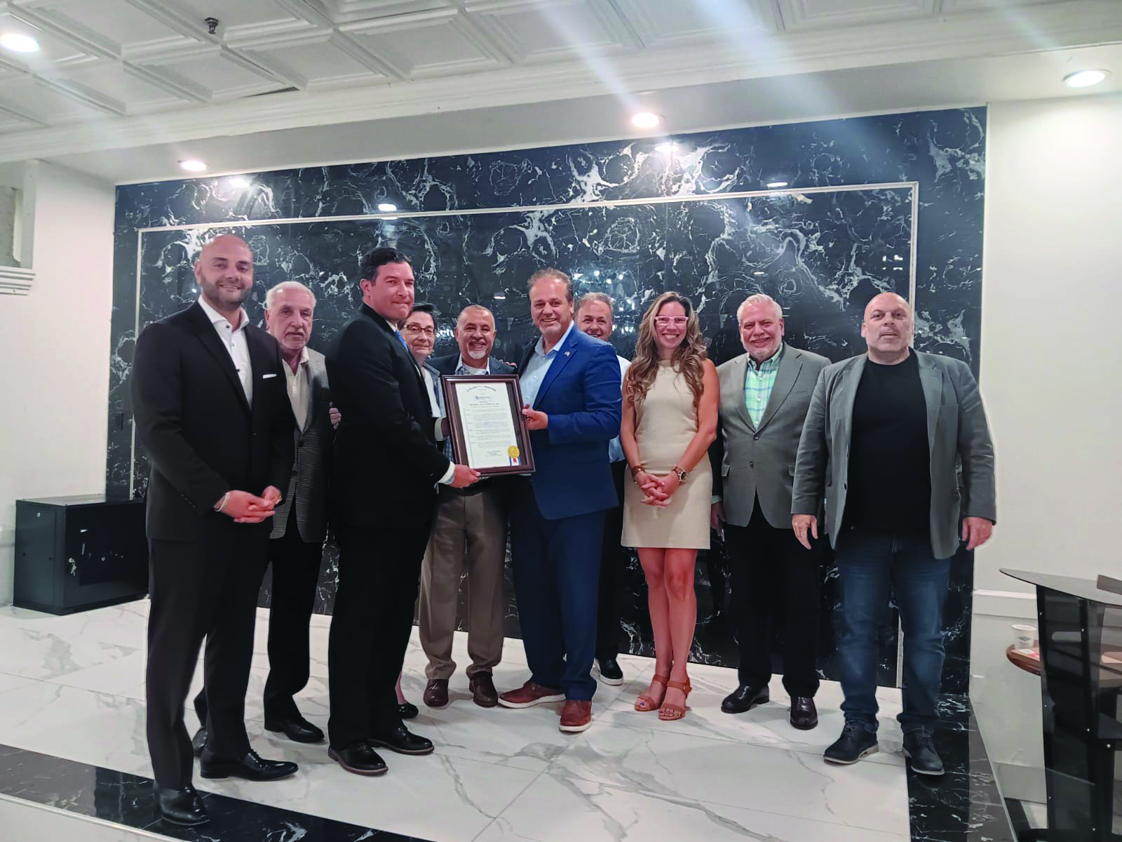 Russ Kavalhuna receiving a certificate of recognition from Wayne County Commissioner Sam Baydoun joined by Dearborn Board of Education Trustees Patrick D'Ambrosio, Mary K. Petlichkoff, Irene Watts, Jamal Aljahmi, Amer Zahr, as well as Osama Siblani, Ali Jawad and Assad Turfe.