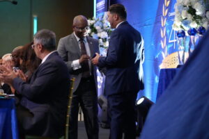 Adian Lewis , CEO of Forgotten Harvest receives his Innovator of the Year Award from Odie Fakhouri