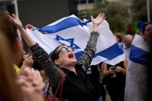 Israelis react with great emotion, following the announcement that Israel and Hamas have agreed to the first phase of a peace plan to pause the fighting, at a plaza known as Hostages Square in Tel Aviv on Thursday. -AP