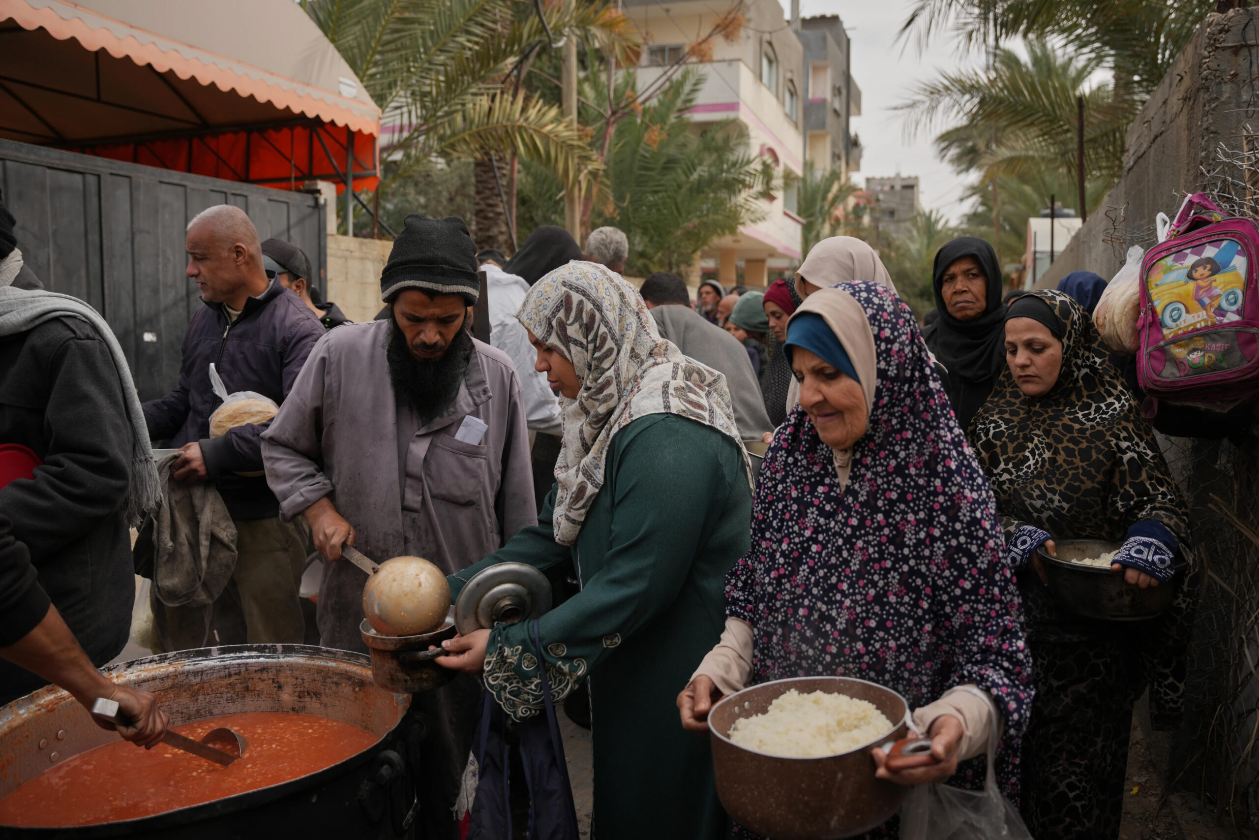 Palestinian women receive donated food at a community kitchen in Deir al-Balah, central Gaza Strip, Wednesday, January 21. - Photo by AP