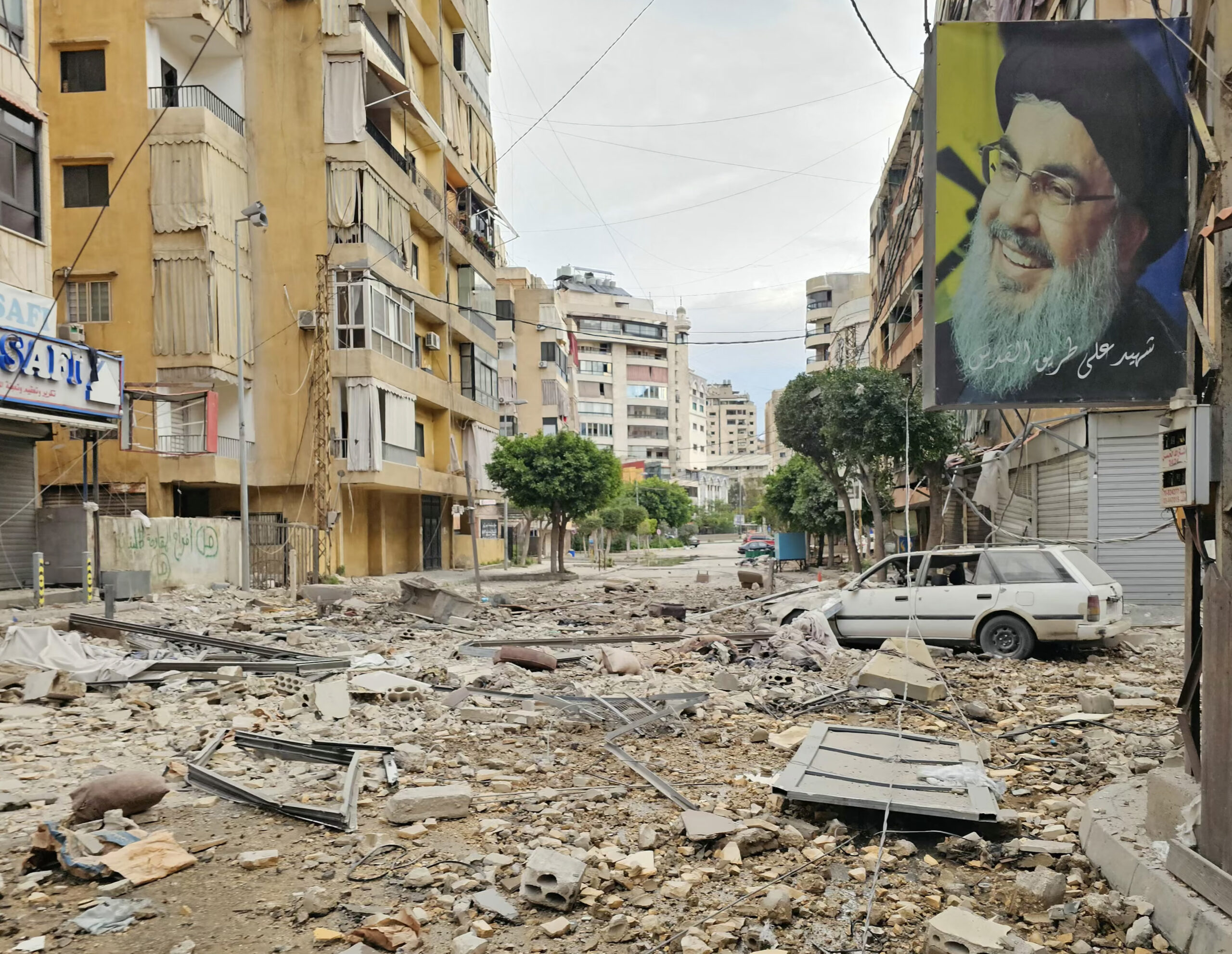 A banner bearing the image of Hassan Nasrallah, the assassinated Hezbollah leader, hangs from a building in a Beirut street targeted by an Israeli airstrike. Photograph: AFP